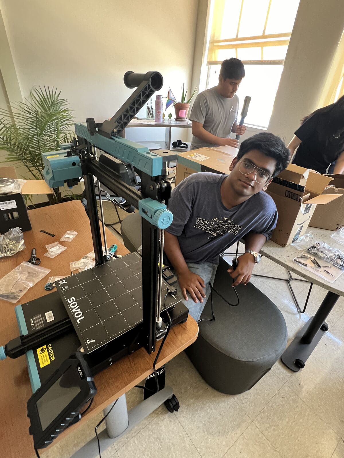 Member seated beside a Sovol 3D printer during assembly