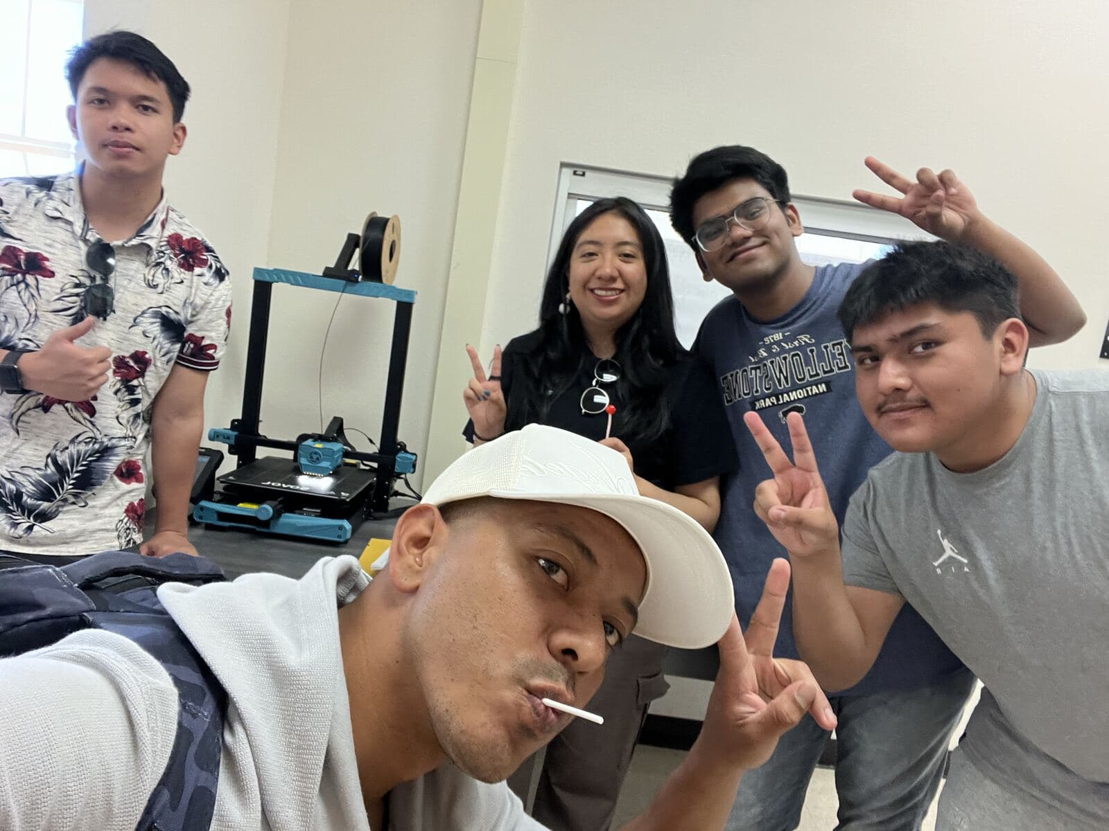Group selfie of chapter members next to a 3D printer
