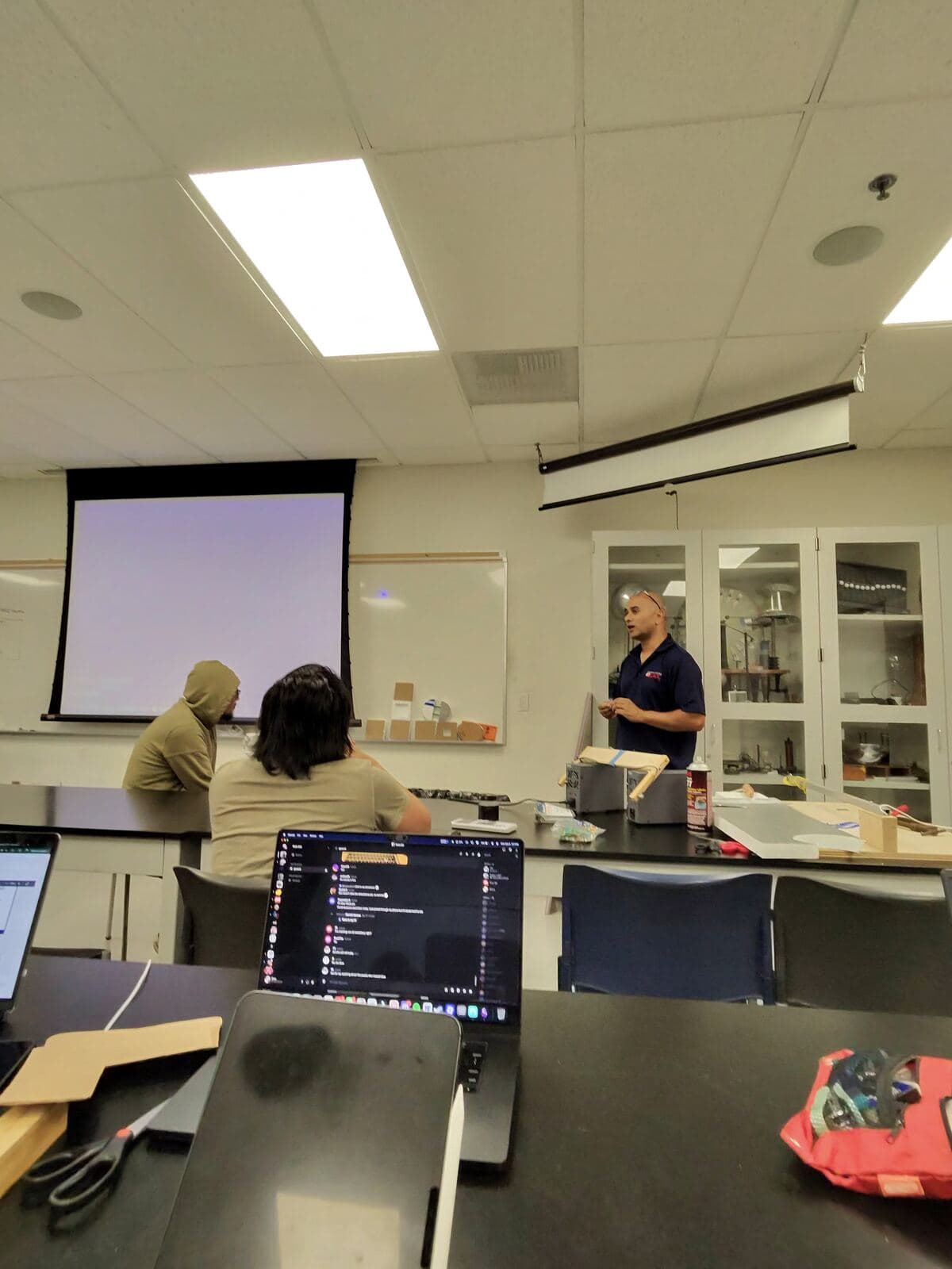 Workshop session in a physics lab with a presenter and members